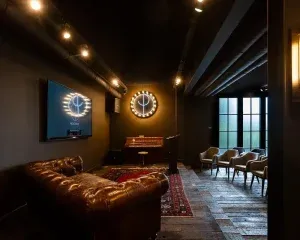 Moderne kantoorruimte met gouden verlichting, bruine lederen bank, grote ramen en designmeubelen voor professionele werkomgeving